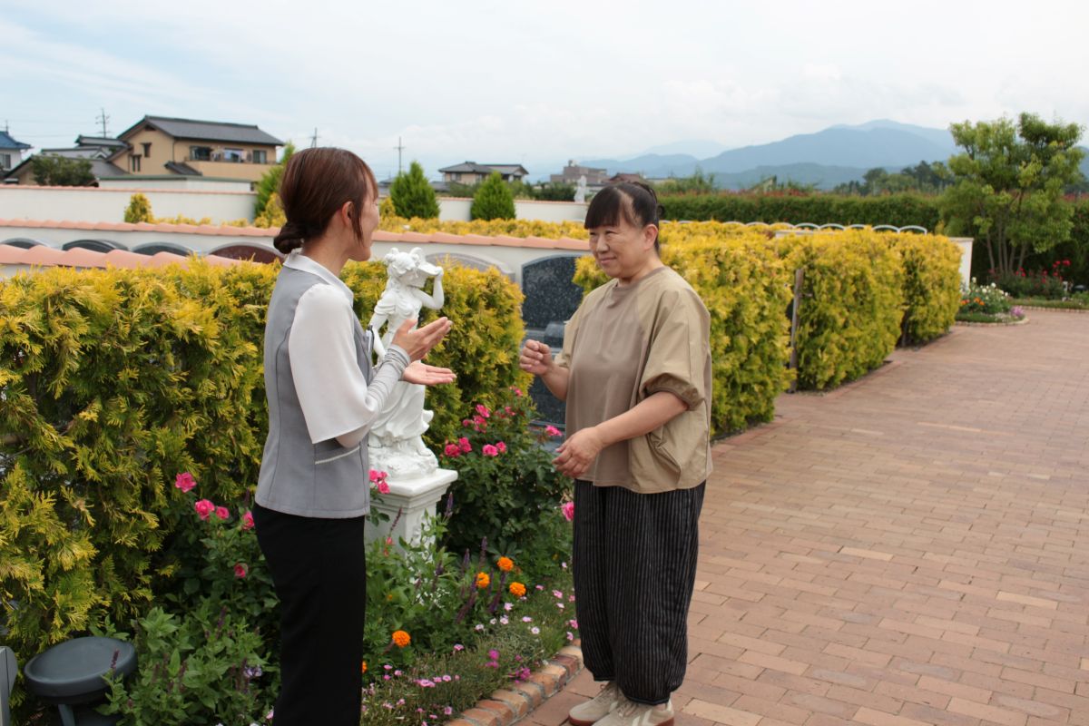 ロイヤルガーデン長野の園内でスタッフと談笑する小野寺様